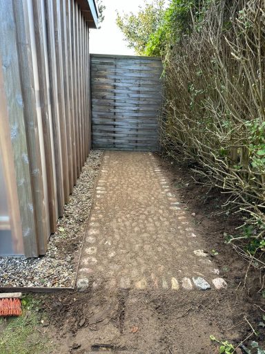 Anlegen eines Weges aus runden Natursteinen